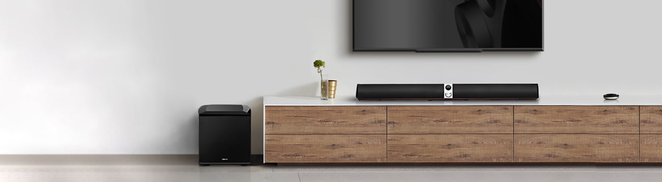 S70DB Soundbar is placed on the counter under a TV and the Subwoofer is placed on the floor.